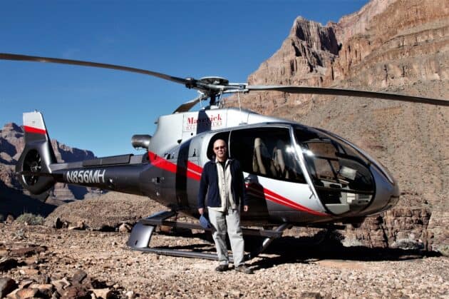 Tom Palagio in piedi davanti all'elicottero. Industria mineraria
