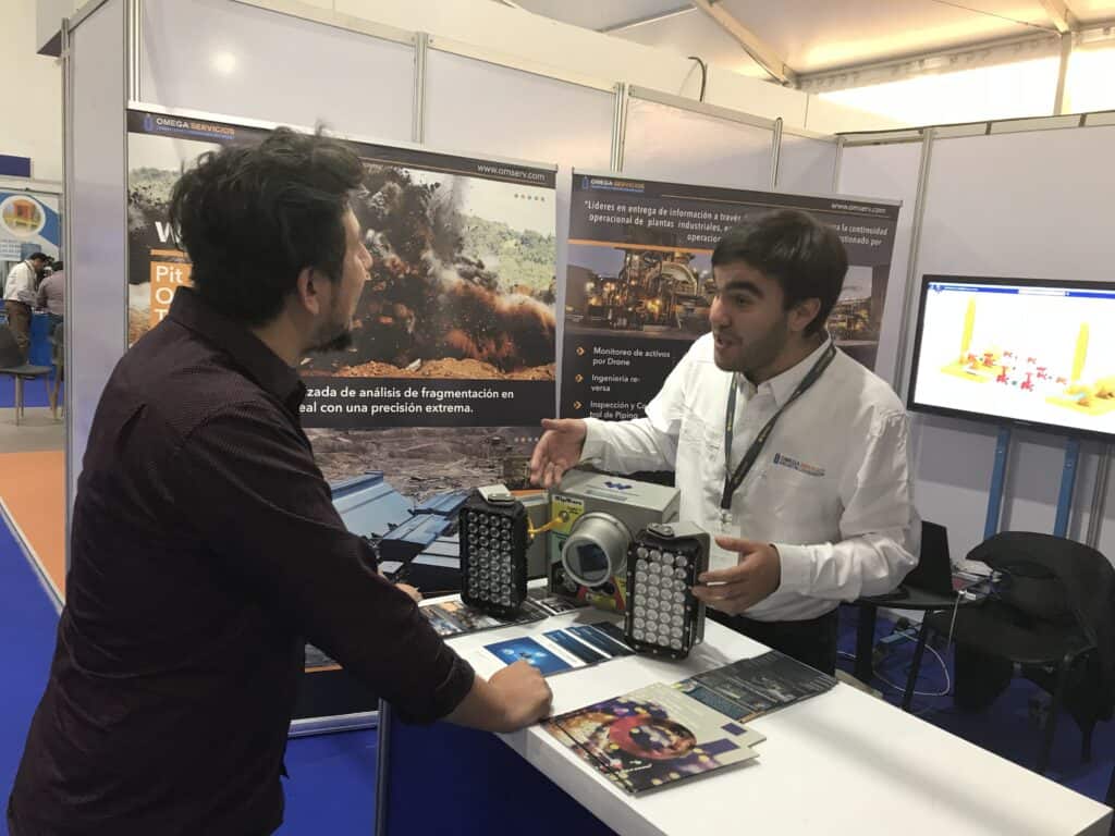 Omega Servicios rep talking to booth visitor