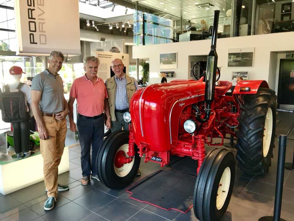 Red tractor with men standing beside it