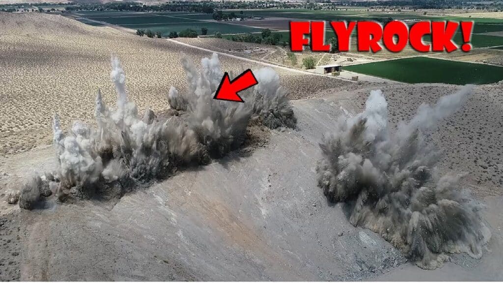 rock blasting into the air with pieces of rock flying up